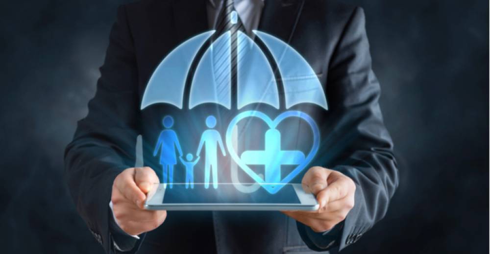 Man in suit holding a tablet with a hologram of a family and a heart under an umbrella